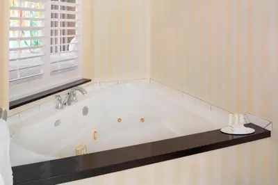 a white bath tub in a bathroom with a window at Fairfield Inn & Suites by Marriott Selma Kingsburg in Kingsburg