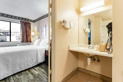 a hotel room with a bed and a sink at Knights Inn Madera in Madera