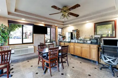 a kitchen with a table and chairs and a ceiling fan at Knights Inn Madera in Madera