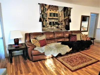 a brown leather couch in a living room with a table at NEW CHARMING 2 BEDROOMS UNIT CLOSE TO EVERYTHING in Oakhurst