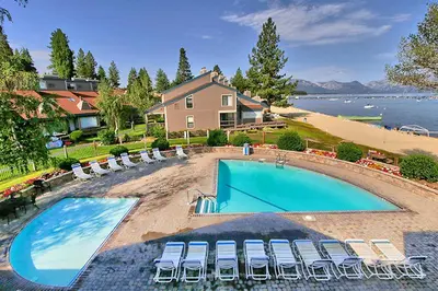 a large swimming pool with chairs and a house at South Lake Tahoe Resort - Steps to Beach & Close to Heavenly in South Lake Tahoe