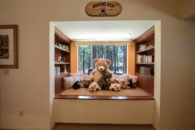 a large teddy bear sitting on a couch in a library at Bruin's Den in Wawona