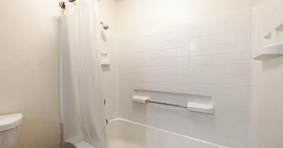 a white bathroom with a toilet and a shower at Budget Inn and Suites Stockton Yosemite in Stockton