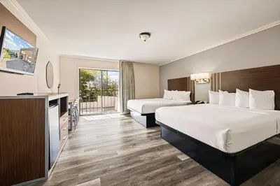 a hotel room with two beds and a balcony at Heritage Inn Express Roseville in Roseville