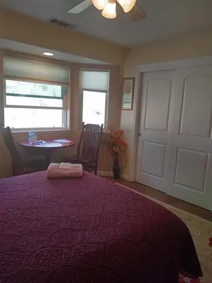 a bedroom with a purple bed with a table and window at Engvadonia Yosemite B and B in Mariposa