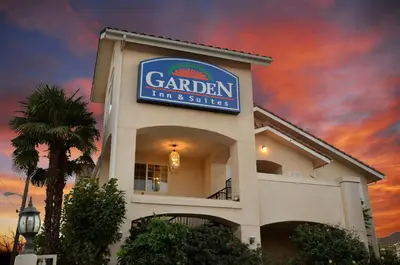a building with a sign for a garden inn and suites at Garden Inn and Suites Fresno in Fresno