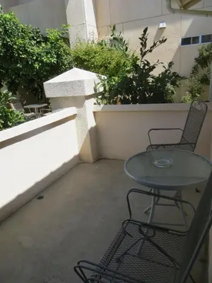 a glass table and two chairs on a balcony at Garden Inn and Suites Fresno in Fresno