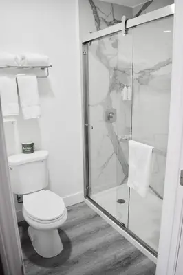 a bathroom with a toilet and a glass shower at Super 8 by Wyndham Visalia in Visalia