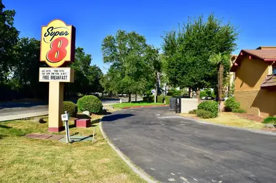 a sign for a super motel next to a street at Super 8 by Wyndham Visalia in Visalia