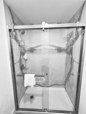 a shower with a glass door in a bathroom at Super 8 by Wyndham Visalia in Visalia