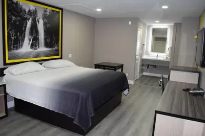 a bedroom with a large bed and a bathroom at Super 8 by Wyndham Visalia in Visalia
