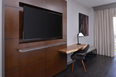 a hotel room with a desk and a flat screen tv at Visalia Marriott at the Convention Center in Visalia