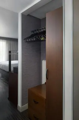 a bedroom with a bed and a closet with a dresser at Visalia Marriott at the Convention Center in Visalia