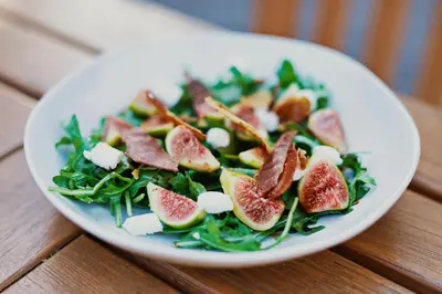 a plate of salad with grapefruit and greens on a table at Appellation Lodi - Wine & Roses Resort and Spa in Lodi