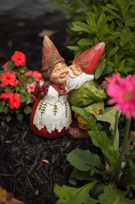 a small gnome statue in a garden with flowers at Poppy Sister Inn in Lodi