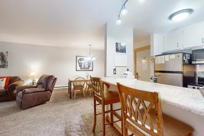 a kitchen and living room with a counter and chairs at The Summit 206 in Old Mammoth