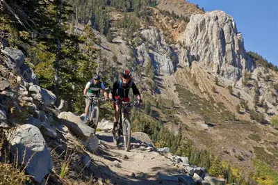 two people riding bikes on a mountain trail at The Summit 206 in Old Mammoth