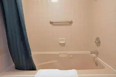 a bathroom with a tub with a toilet and a shower curtain at Days Inn by Wyndham Gilroy in Gilroy
