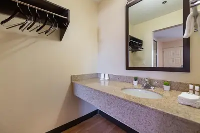 a bathroom with a sink and a mirror at California Inn and Suites, Rancho Cordova in Rancho Cordova