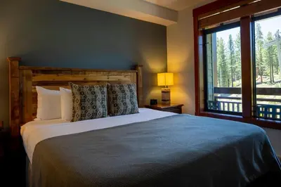 a bedroom with a bed and a large window at The Village Lodge in Mammoth Lakes