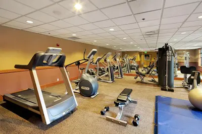 a gym with several treadmills and cardio machines at The Village Lodge in Mammoth Lakes