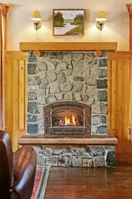 a stone fireplace in a living room with a fire place at Tamarack Lodge in Mammoth Lakes