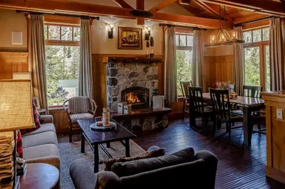 a living room with a fireplace and a table and chairs at Tamarack Lodge in Mammoth Lakes
