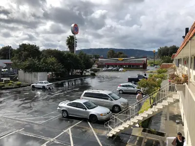 a group of cars parked in a parking lot at Gilroy Inn in Gilroy