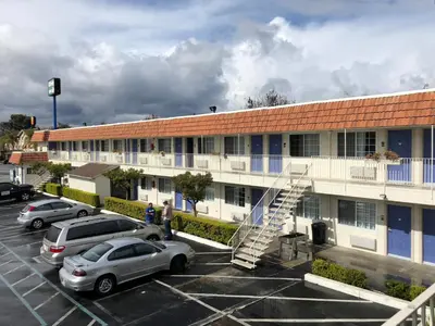 a parking lot with cars parked in front of a building at Gilroy Inn in Gilroy
