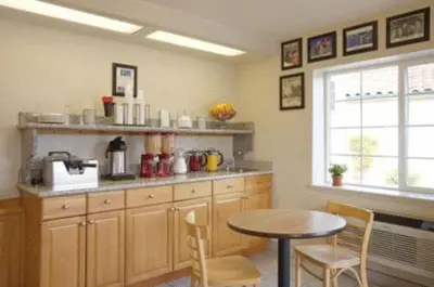 a kitchen with a table and a table and chairs at Turlock Inn in Turlock