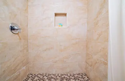 a bathroom with a shower with a tiled shower at Turlock Inn in Turlock