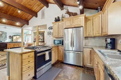 a kitchen with wooden cabinets and a stainless steel refrigerator at Lazy Bear Retreat in Mevers