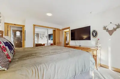 a bedroom with a large bed and a flat screen tv at Lazy Bear Retreat in Mevers