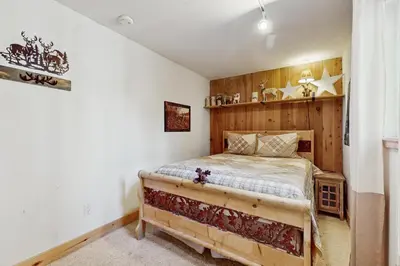 a bedroom with a bed with a wooden wall at Lazy Bear Retreat in Mevers