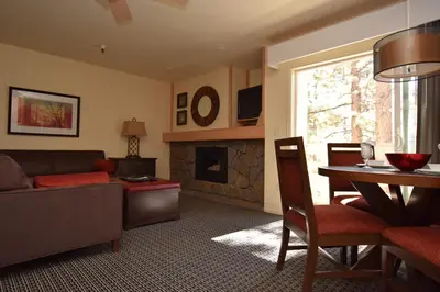 a living room with a couch a table and a fireplace at Lodge at Kingsbury Crossing in Stateline