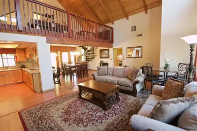 a living room with a couch and a table at Mountain View Playhouse Near Yosemite & Bass Lake in Oakhurst