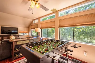 a living room with a pool table in front ofwindows at Mountain View Playhouse Near Yosemite & Bass Lake in Oakhurst