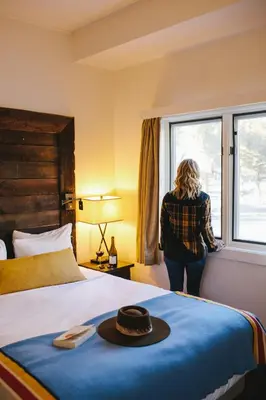 a woman standing in a hotel room with a bed at Sunnyside Resort and Lodge in Tahoe City