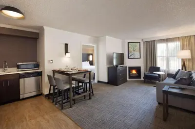 a living room with a kitchen and a living room with a couch at Sonesta ES Suites Fresno in Fresno