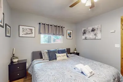 a bedroom with a bed and a ceiling fan at Peaceful Pines Retreat in Mevers
