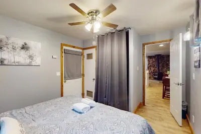 a bedroom with a bed and a ceiling fan at Peaceful Pines Retreat in Mevers