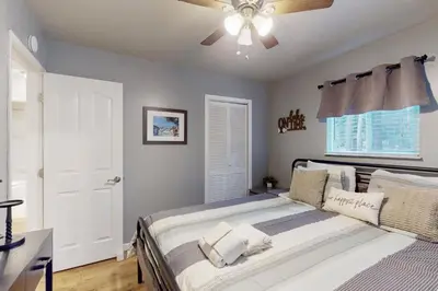 a bedroom with a bed with a ceiling fan at Peaceful Pines Retreat in Mevers