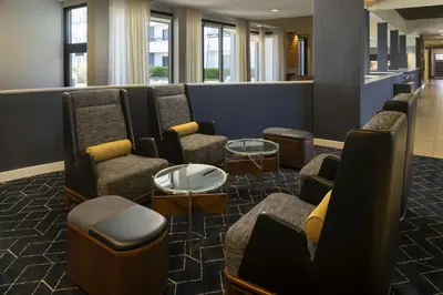 a waiting room with couches and chairs and tables at Courtyard by Marriott Fresno in Fresno