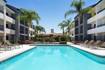 an image of a swimming pool at a apartment complex at Courtyard by Marriott Fresno in Fresno