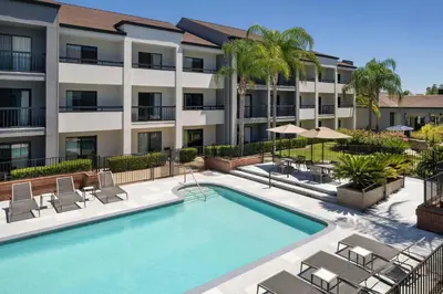an image of a swimming pool at a apartment complex at Courtyard by Marriott Fresno in Fresno
