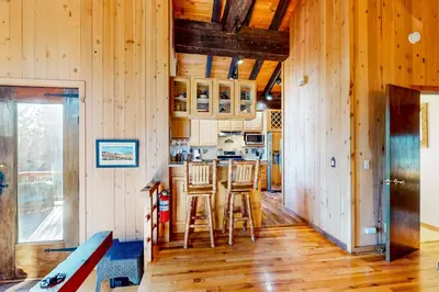 a kitchen with wooden walls and a counter with stools at Commonwealth Retreat in Kings Beach