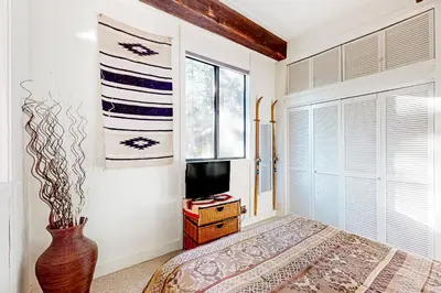 a bedroom with a bed and a tv and a window at Commonwealth Retreat in Kings Beach
