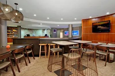 a restaurant with tables and chairs and a bar at SpringHill Suites by Marriott Madera in Madera