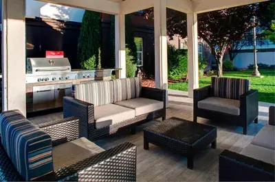 a patio with a grill and chairs and a table at TownePlace Suites Fresno in Fresno