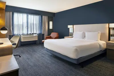 a hotel room with a large white bed and a window at Courtyard by Marriott Sacramento Midtown in Sacramento